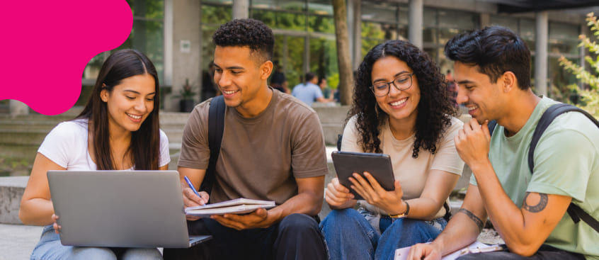 Estudiantes de posgrado en comunicación digital trabajando en equipo durante una clase presencial.​